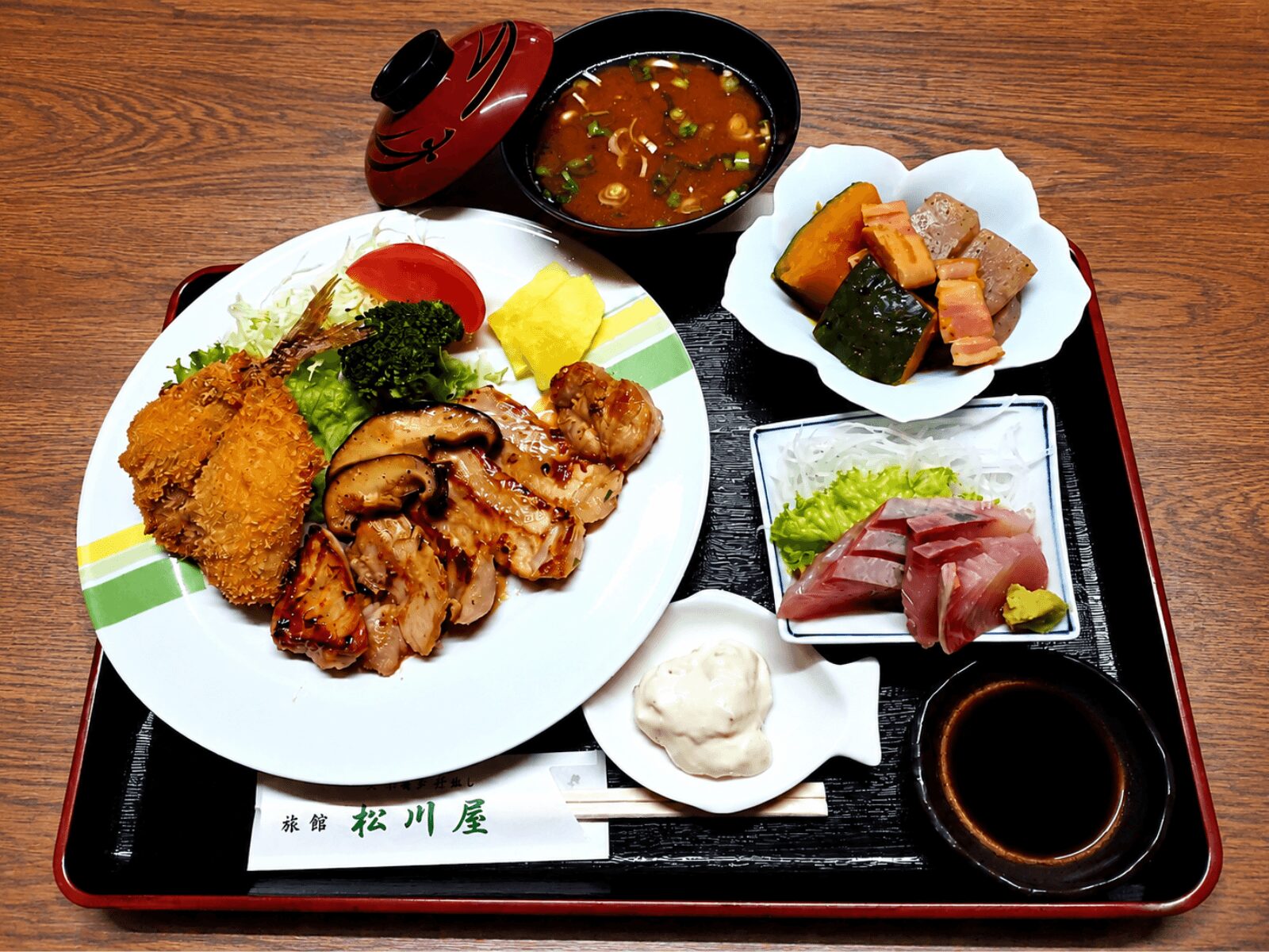 松浦旅館の松川屋旅館で提供する出張宿泊向けの夕食。刺身、揚げ物、焼き物、副菜、汁物が並ぶ食事付き宿泊